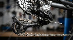 Механизм переключения скоростей велосипеда - цепь, кассета и задний переключатель с роликами в момент смены передачи